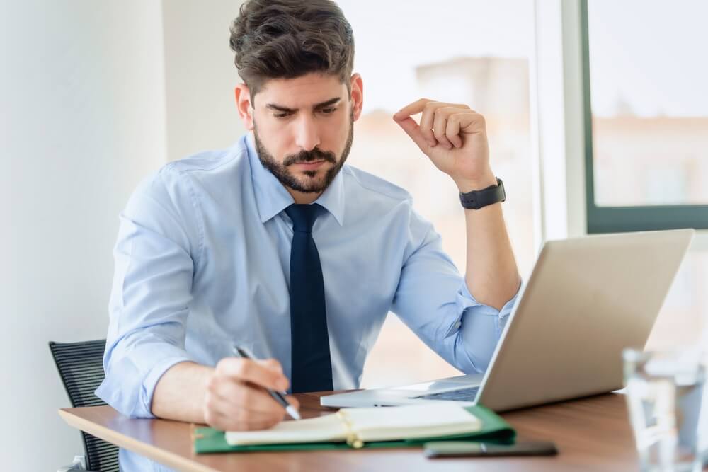Thinking Businessman writing on a notepad