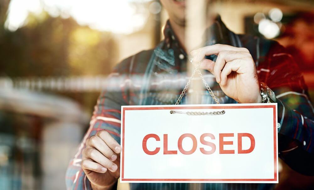 Man hanging closed sign