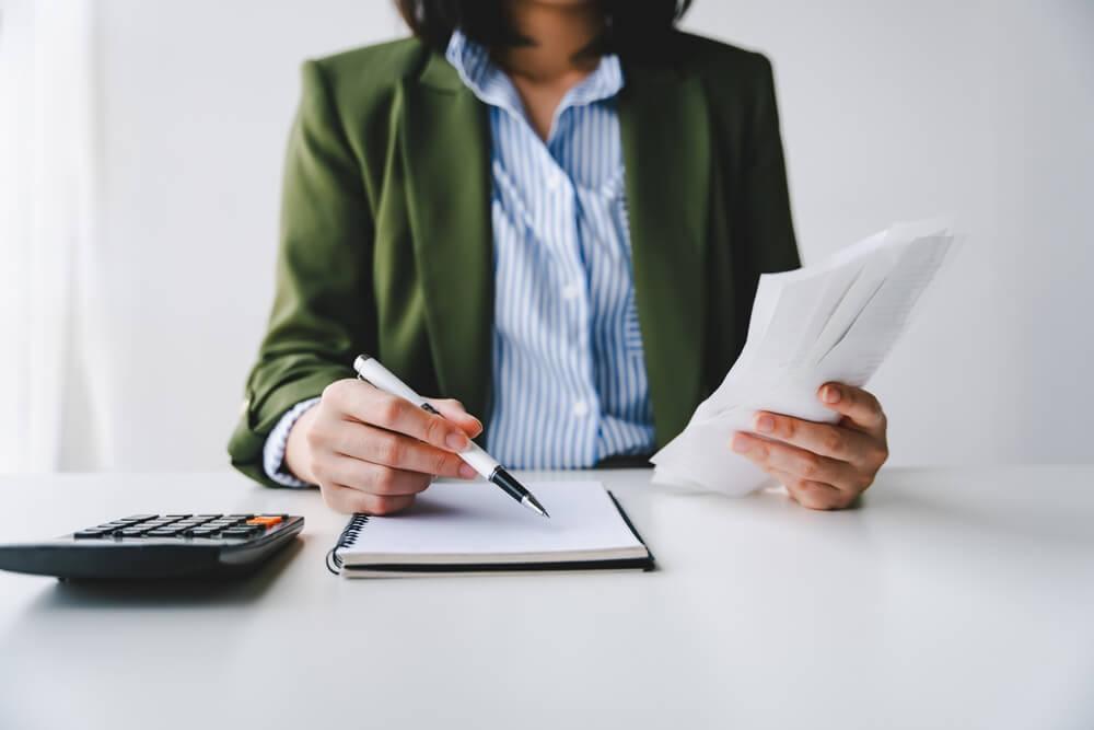 Business woman writing on a note pad